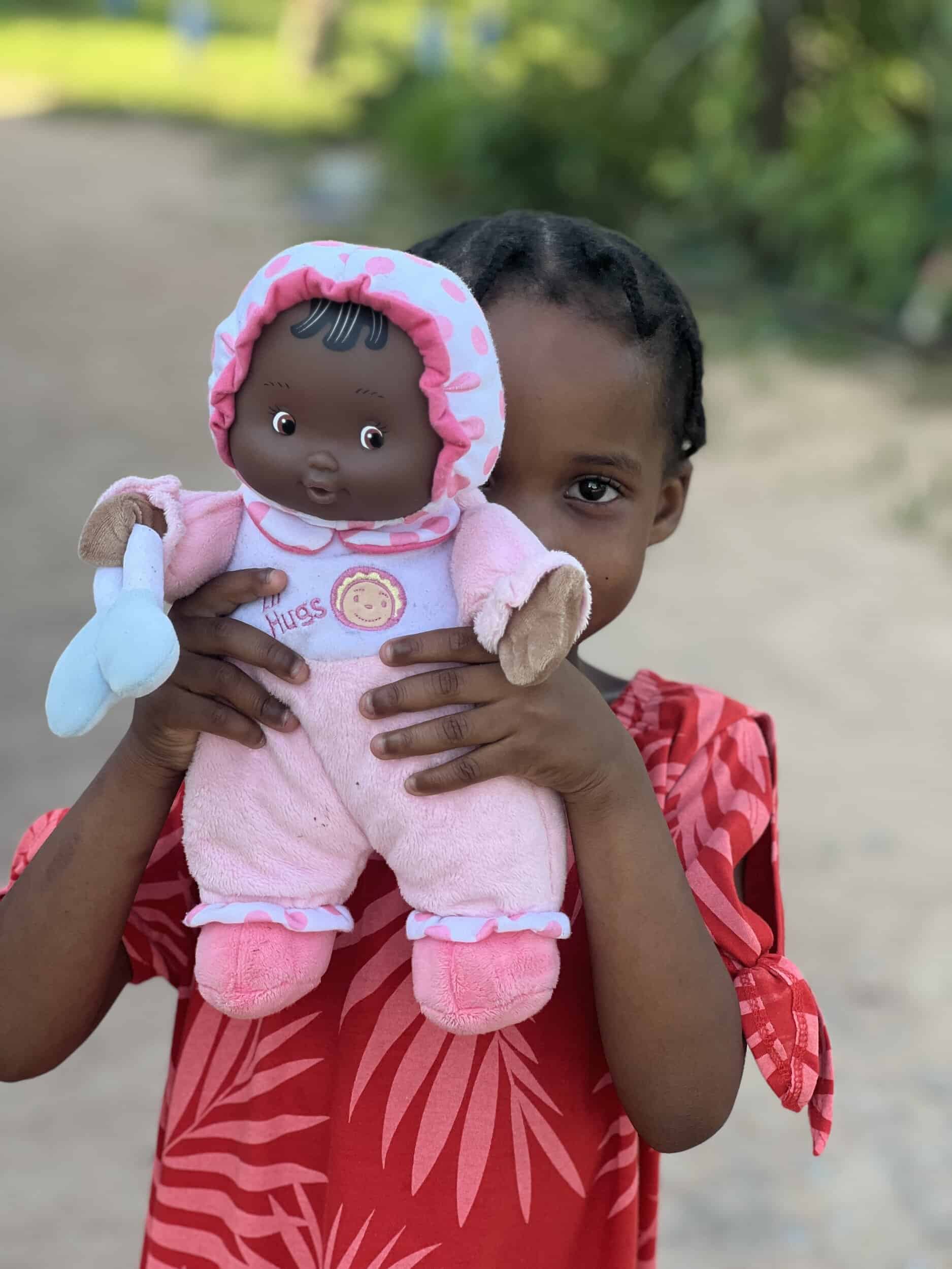 Young African girl holding African doll